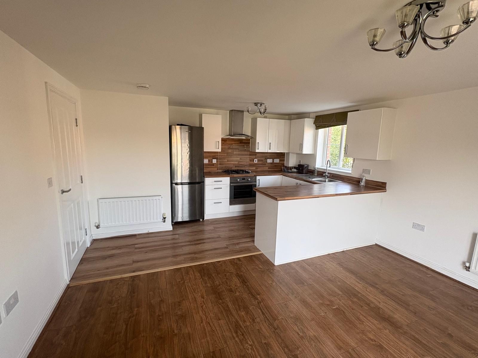 Completed residential flat refurbishment showing the kitchen and open-plan living area